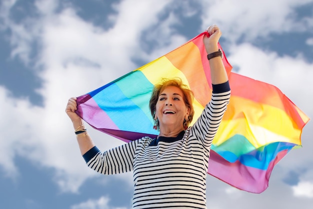 Older lady waving the rainbow flag of the gay community Gay Pride Day Fight for rights for gays