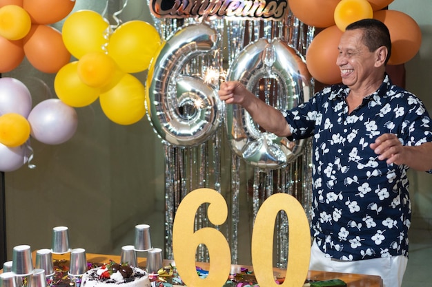 Older man enjoying a birthday celebration while holding sparklers