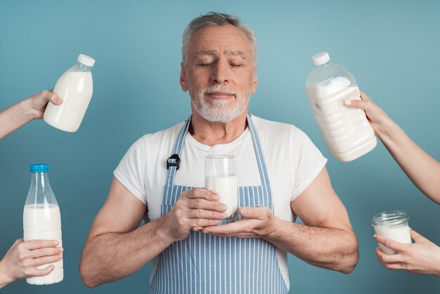 L'uomo più anziano tiene un bicchiere di latte nelle sue mani