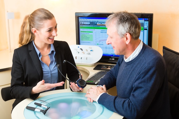 Older man or pensioner with a hearing problem make a hearing test and may need a hearing aid