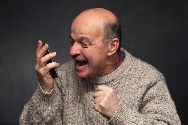 L'uomo più anziano urla nel telefono con rabbia