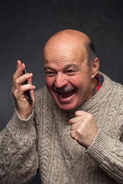 Older man yells into the phone in anger