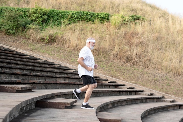 Older mature athletic man in good shape running down stairs Healthy lifestyle for retirement
