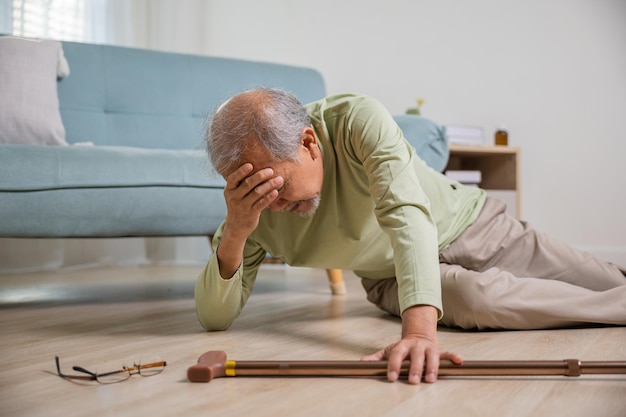 Older senior man headache lying on the floor after falling