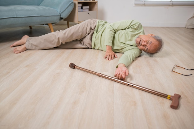 Older senior man headache lying on the floor after falling