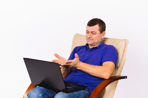 An older surdomute caucasian man communicates by video through a laptop, gesturing hands