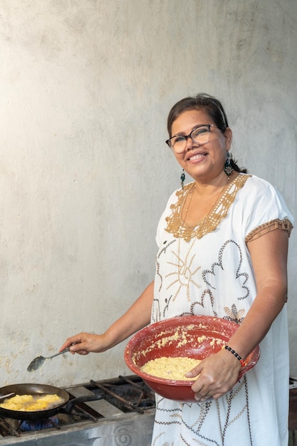 Older Woman cooking a traditional Colombian and Mexican dish made with corn dough