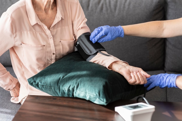 看護師に血圧チェックを受けている年配の女性