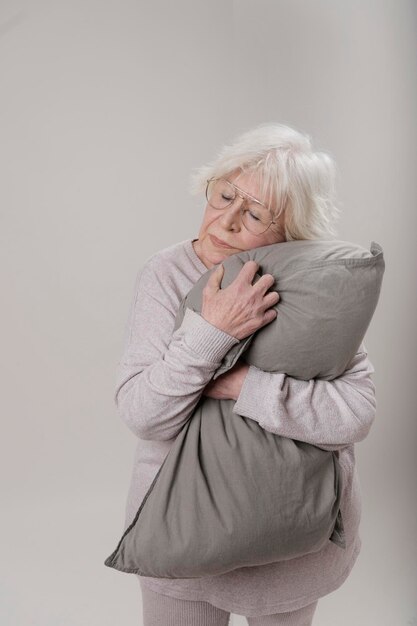 older woman hugging a pillow