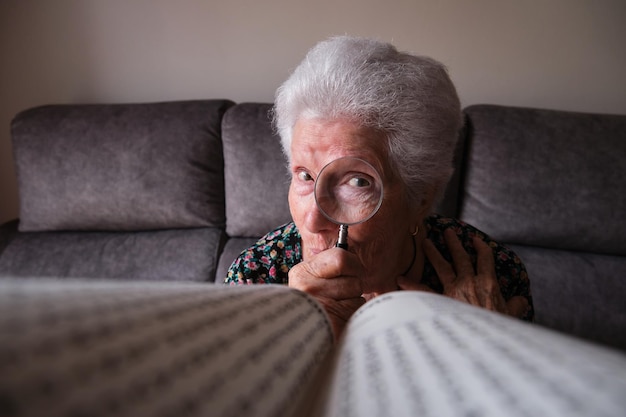 Older woman looking through a magnifying glass