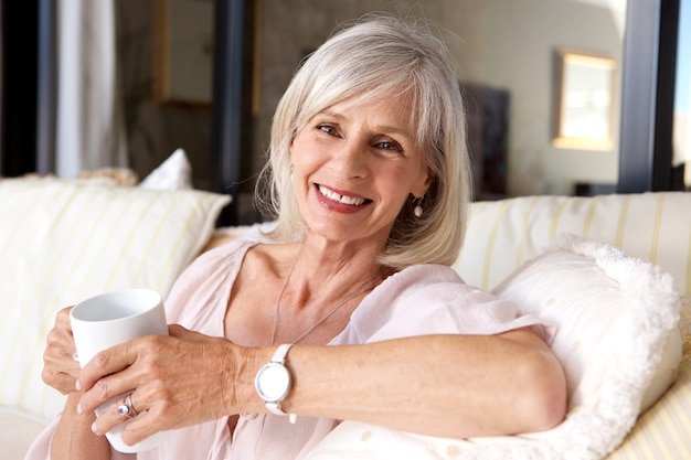 Older woman sitting on couch with coffee