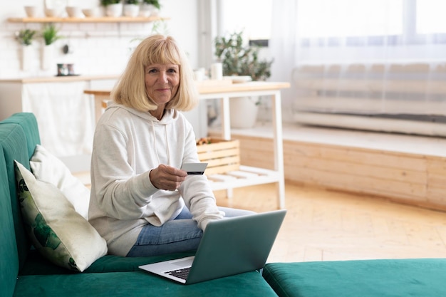 Photo older woman using laptop and credit card to shop online