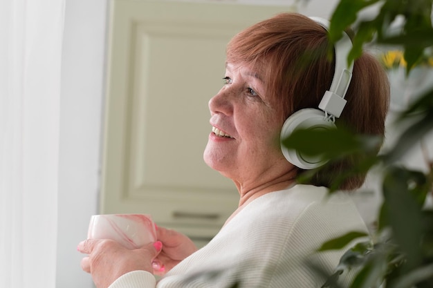 Older woman with a serene expression gazes out of window radiating a sense of grace and contentment