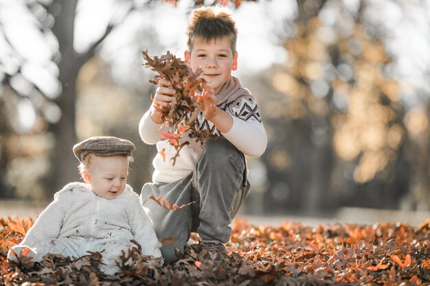 Foto il bambino più grande abbraccia e comunica con il suo fratello di 6 mesi i bambini seduti nel parco trascorrono del tempo insieme