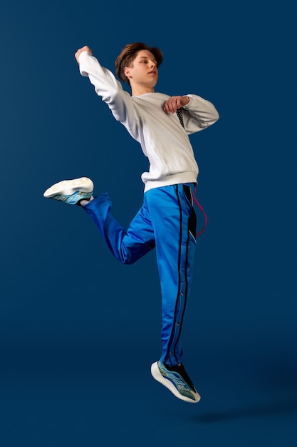 Oldschool fashioned young man dancing isolated on blue background