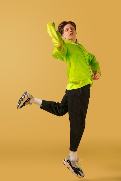 Oldschool fashioned young man dancing isolated on yellow background