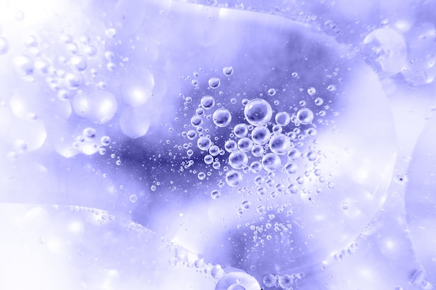 Oliebellen sluiten zich. cirkels van water macro. abstracte lichtblauwe achtergrond. Zeer Peri-kleur van het jaar