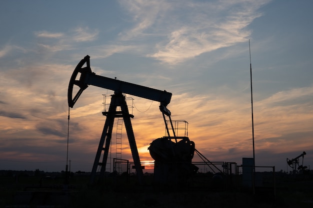 Oliepomp op oranje zonsondergang