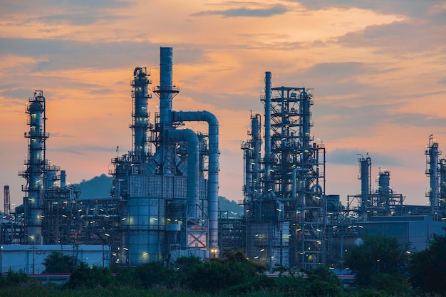 Olieraffinaderij en fabriek en torenkolom van de petrochemie-industrie in olie- en gasindustrie met wolkenrode lucht