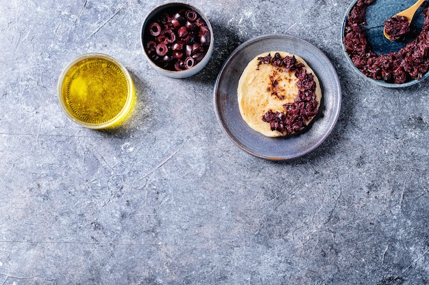 Olijf tapenade geserveerd met zelfgebakken brood