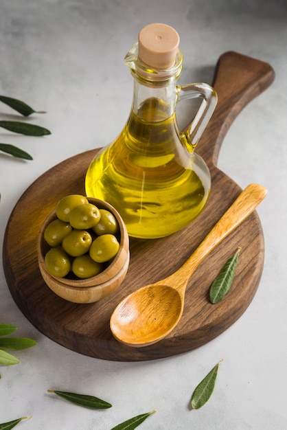 Olijfolie en olijfolie op een houten bord met blaadjes