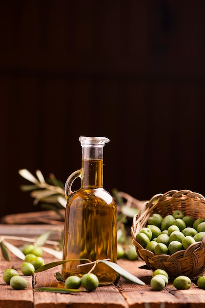 Olijfolie en olijven op houten rustieke tafel