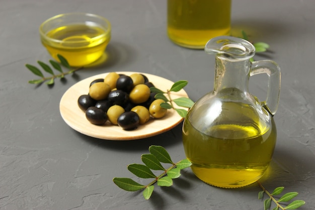 Olijfolie groene bladeren en olijven op tafel