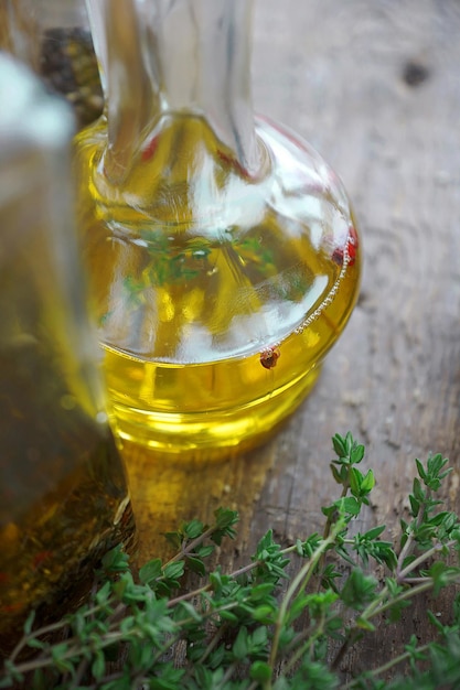 Olijfolie in een glazen fles met kruiden, rode peper en tijm