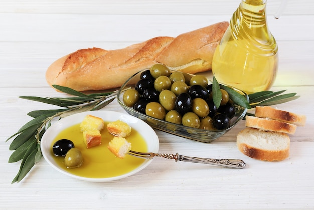 Olijven, olijfolie en brood op de houten tafel