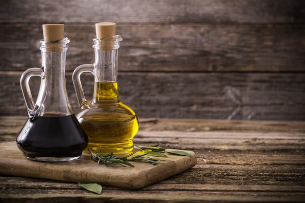 Оливковое масло и бальзамический уксус на деревянном фоне