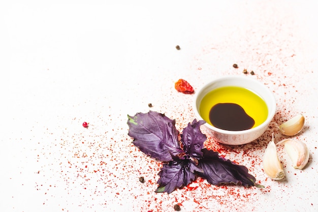 Olive oil, basil and spices on a white background.