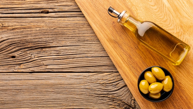 Photo olive oil bottle and yellow olives with copy space