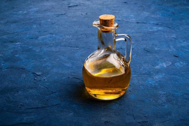 Olive oil in glass bottle on blue table