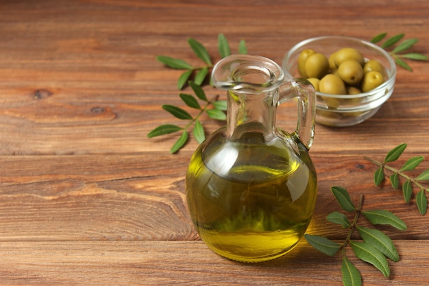 Olive oil green leaves and olives on the table