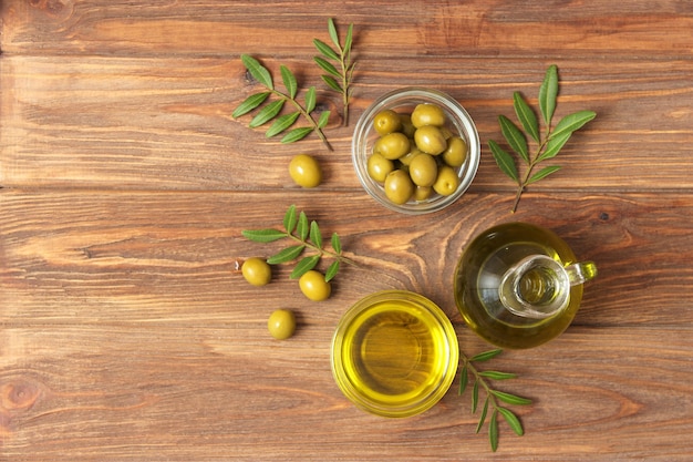 Olive oil green leaves and olives on the table