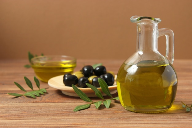 Olive oil green leaves and olives on the table