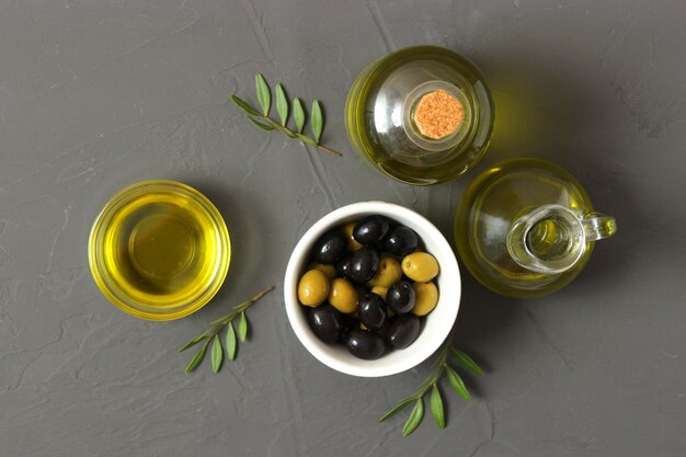 Olive oil green leaves and olives on the table