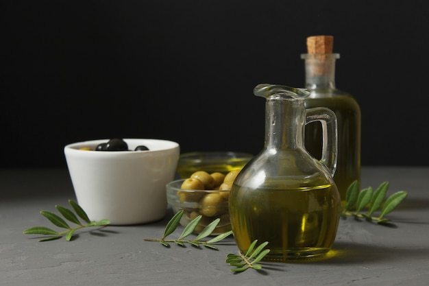 Olive oil green leaves and olives on the table