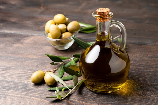 Фото Оливковое масло в бутылке и зеленые оливки