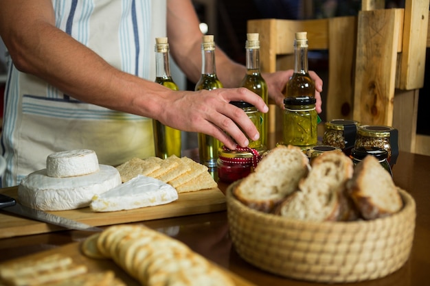 Olive oil, jam, pickle placed together on table