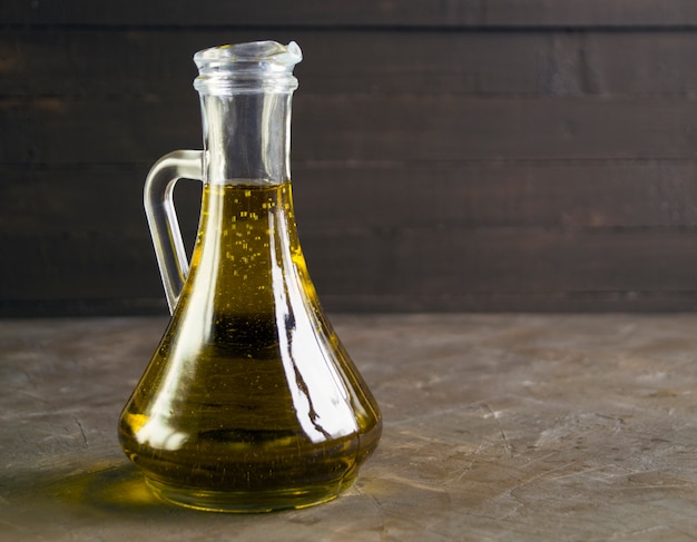 Olive oil in a jug on a dark background.