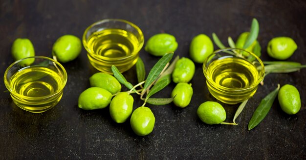 Olio d'oliva e ramo d'ulivo su sfondo nero.