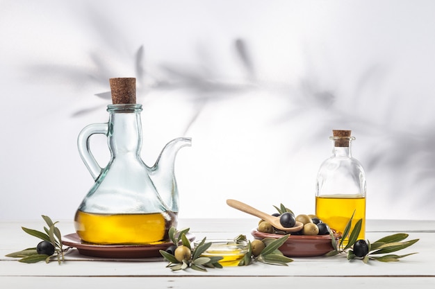 Olive oil and olive branch on the wooden table 