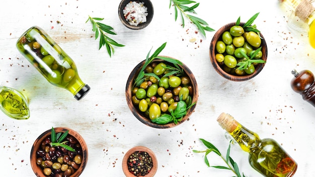 Olive oil and olives on a white wooden background Top view Free space for your text