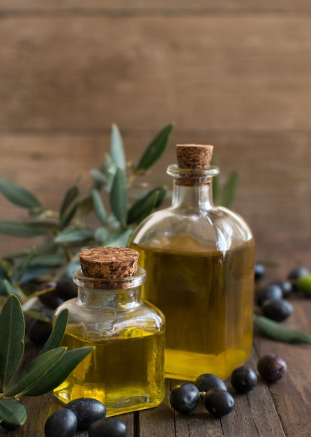 Foto olio d'oliva e olive sulla tavola di legno