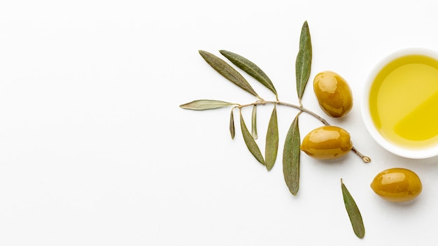 Piattino olio d'oliva con foglie e olive gialle con spazio di copia