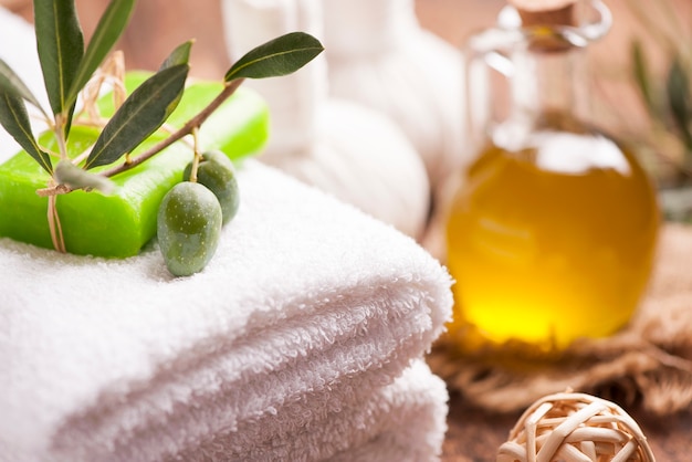 Olive oil soap and bath towel on wooden table