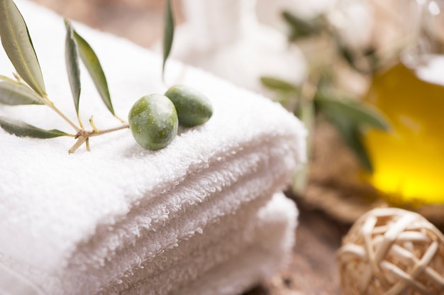 Olive oil soap and bath towel on wooden table