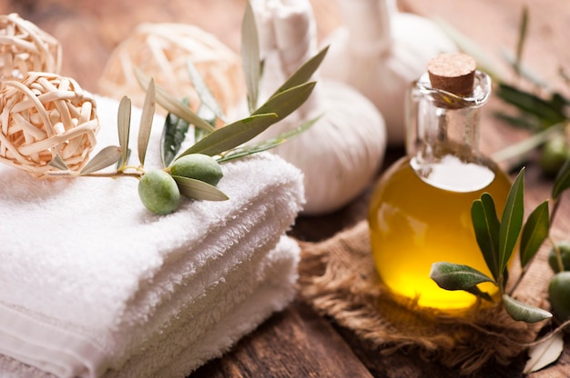 Foto sapone all'olio d'oliva e asciugamano da bagno sul tavolo di legno