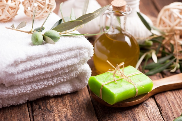 Olive oil soap and bath towel on wooden table